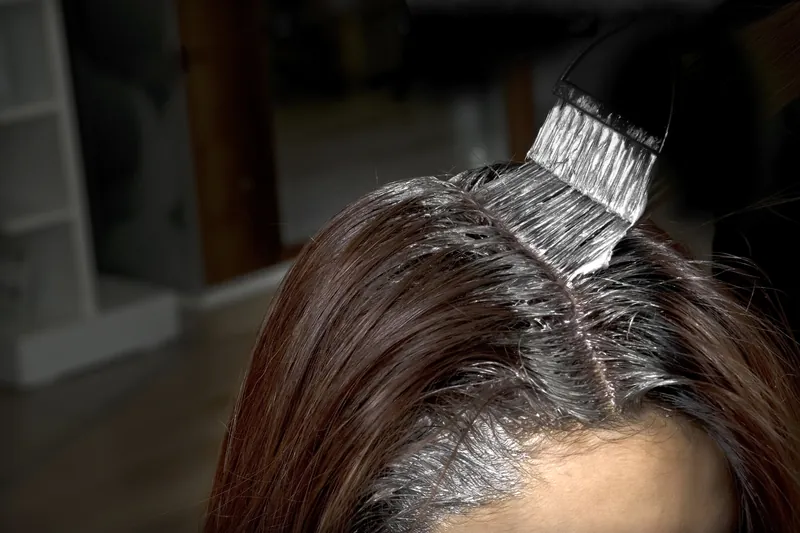 Stylist applying root color for gray coverage at Bella Mia Hair Salon in Billerica MA