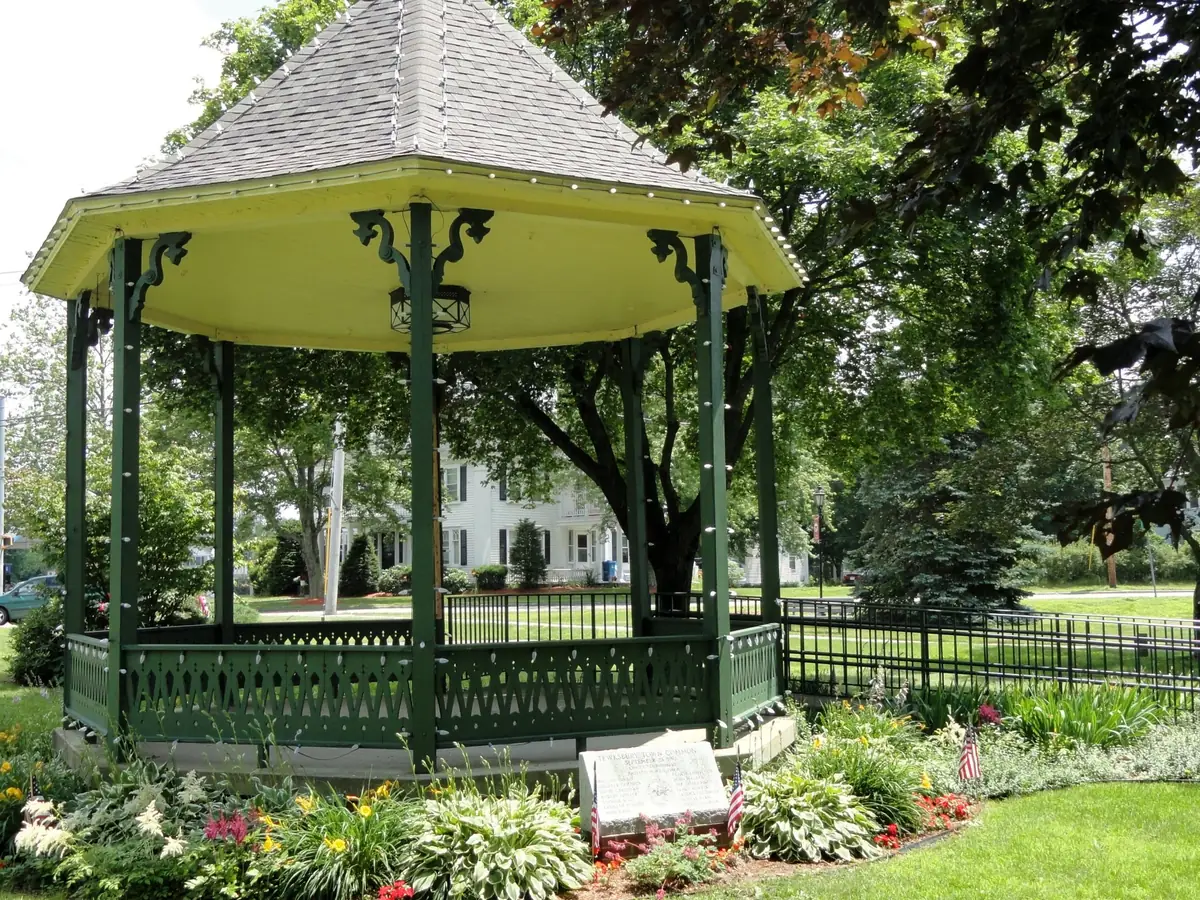 Green Victorian bandstand on the Tewksbury Town Common surrounded by summer flower beds