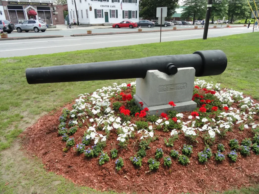 Civil War memorial cannon on the Billerica Town Common, with shops along Boston Road in Billerica Center behind it