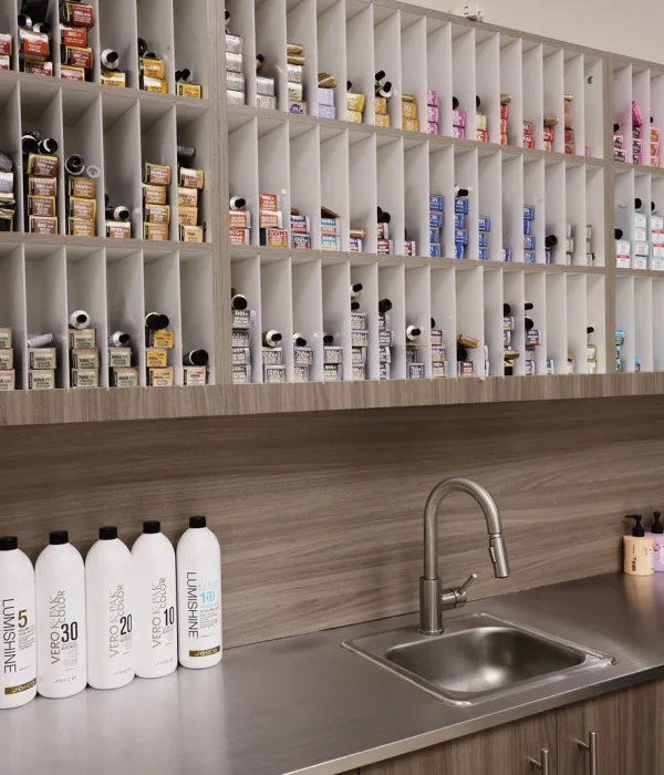 Joico hair color bar at Bella Mia Hair Salon in Billerica, MA, with shelves of color tubes beside the mixing sink