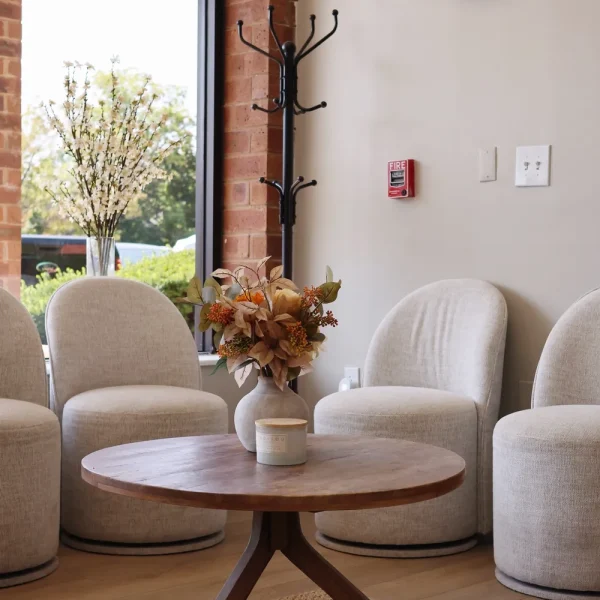 Waiting area with chairs and greenery inside Bella Mia Hair Salon in Billerica, MA