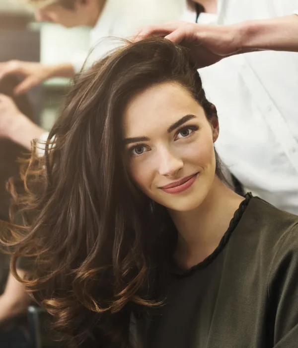 Woman smiling after a voluminous blowout with soft bouncy curls at Bella Mia Hair Salon in Billerica, MA