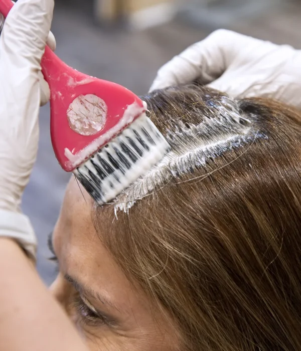 Stylist applying root touch-up color along the part for gray coverage at Bella Mia Hair Salon in Billerica, MA